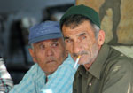Two older men smoking cigarettes