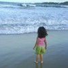 a young child facing an ocean wave