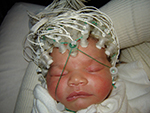 a newborn infant wearing EEG electrodes