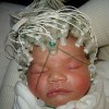 Mother’s Voice Plays Specific Role In Activation Of Newborn Baby’s Brain a newborn baby wearing EEG electrodes