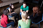 teenagers sitting in a group discussing personal issues