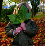 a young child outdoors hiding her face